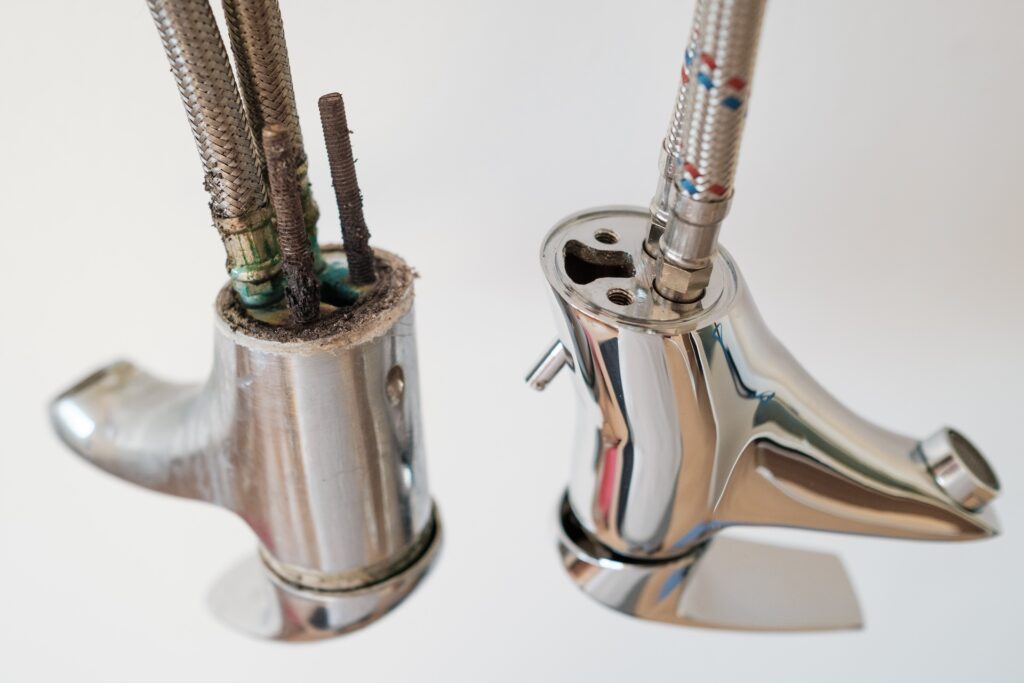 A new and an old faucet or water tap with deposited minerals on the crane aerator.