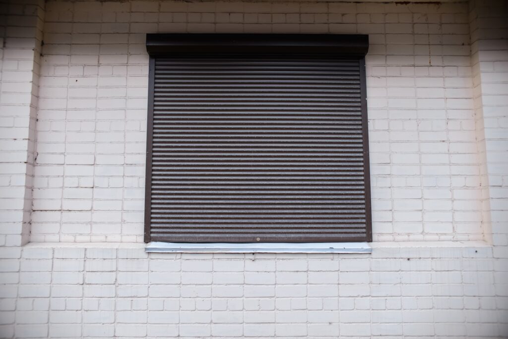 Window shutters on the building. Closed shop. Lockdown, bankruptcy, street riots concept