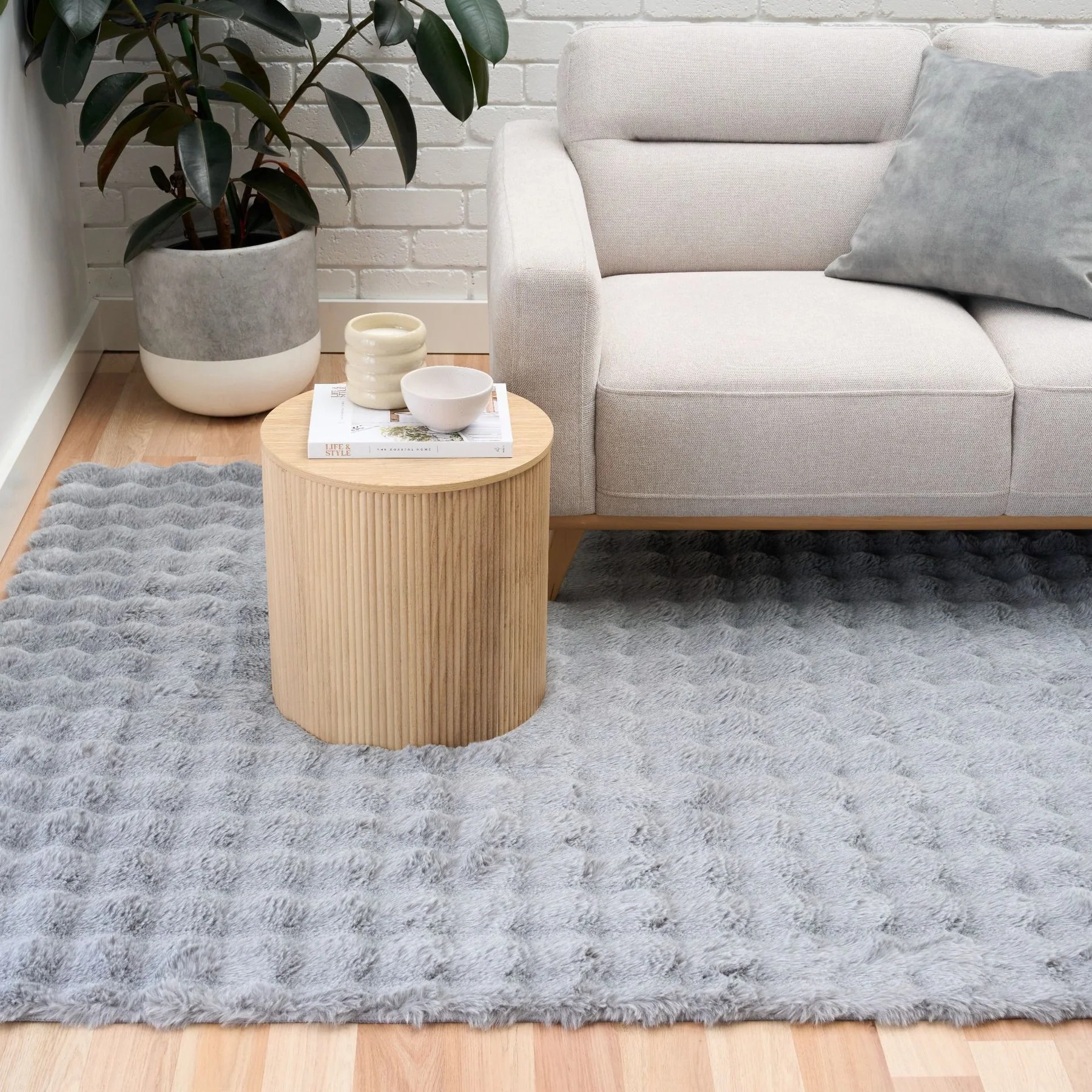 Grey fluffy rug in the living room under the sofa's front legs, anchoring the place and bringing warmth. Credit: Trendsrugs.com.au