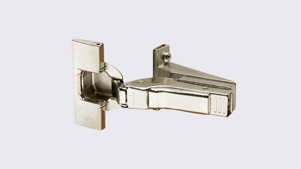 A close-up, high-angle shot shows a inset cabinet hinge against a plain white background