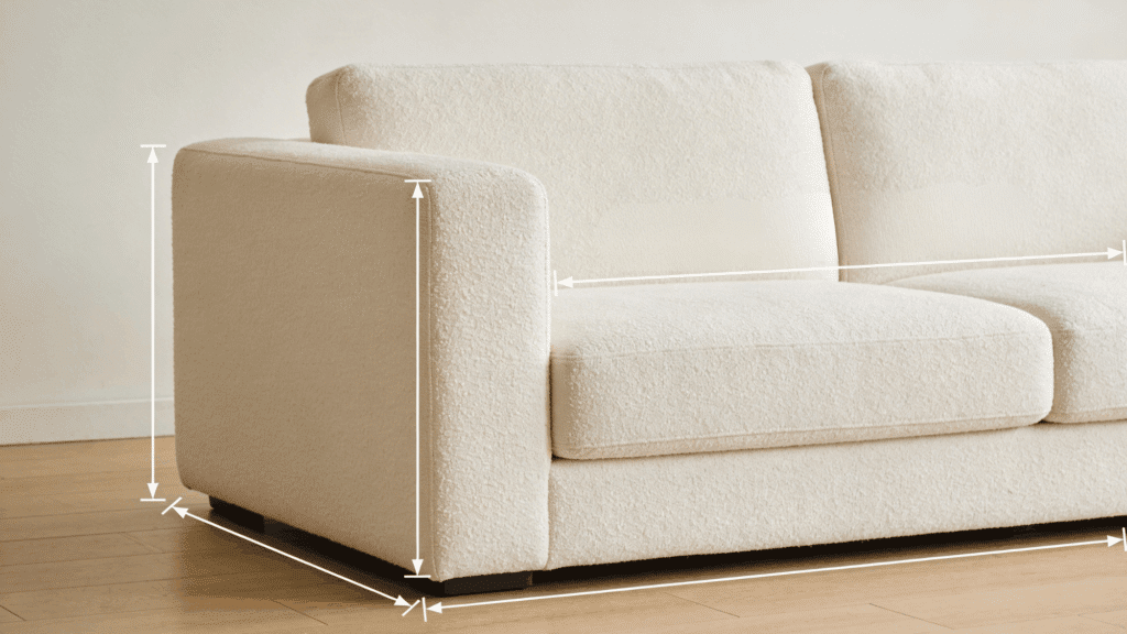 Close-up view of a cream-colored couch with white measurement lines indicating standard couch dimensions.