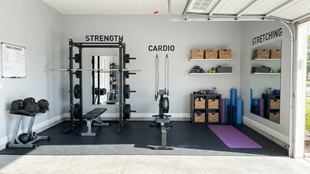 Family friendly half garage gym divided into strength, cardio, and stretching zones