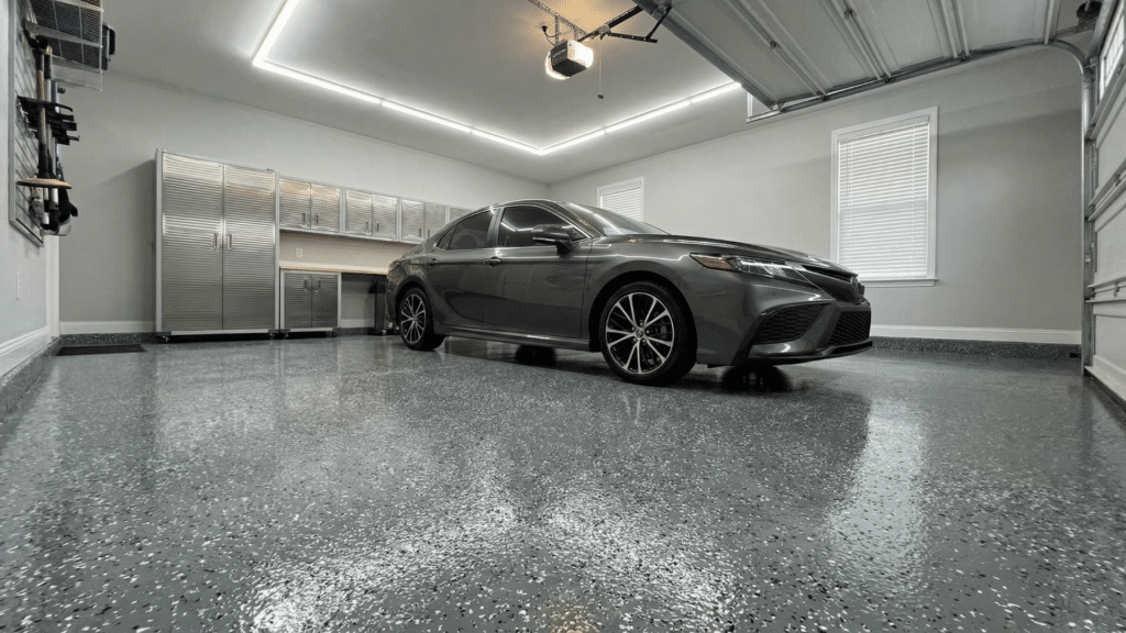 Garage with decorative flake epoxy garage floor coating and a car parked