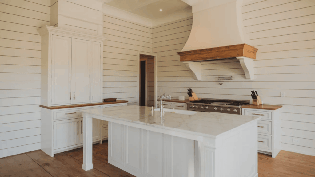 A modern kitchen with marble countertops and white cabinets, featuring a stylish shiplap wall. What is shiplap and why is it popular in kitchens
