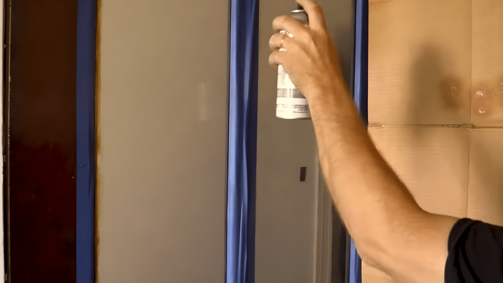 Applying the first light coat of frosted spray paint to glass