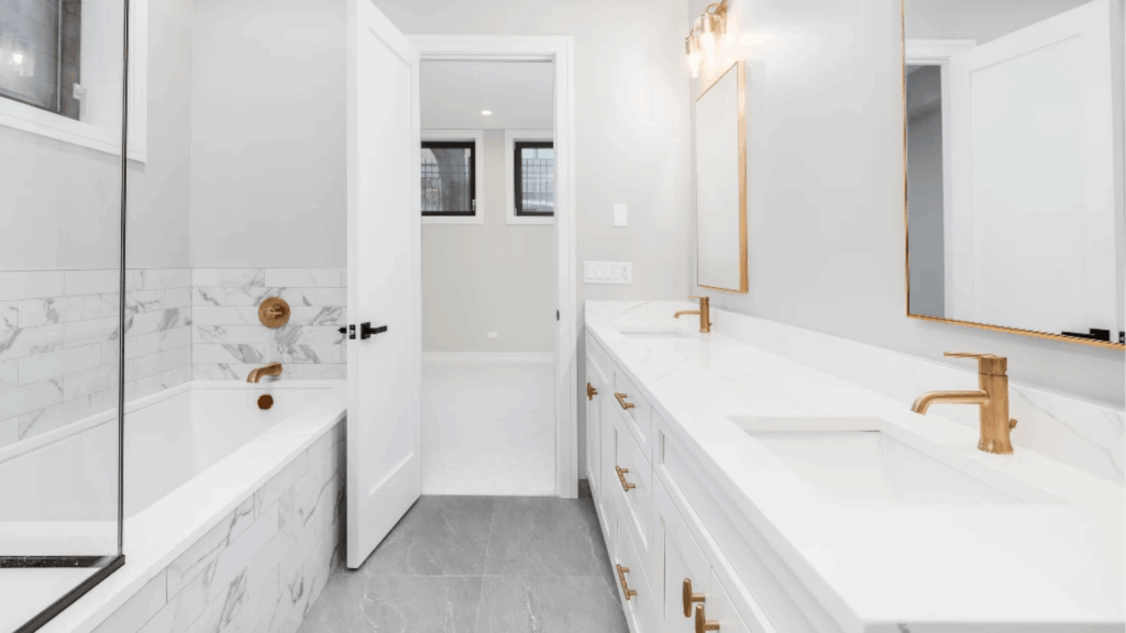 bright modern bathroom with white vanity marble bathtub gold fixtures and large mirror in minimalist japanese bathroom design style