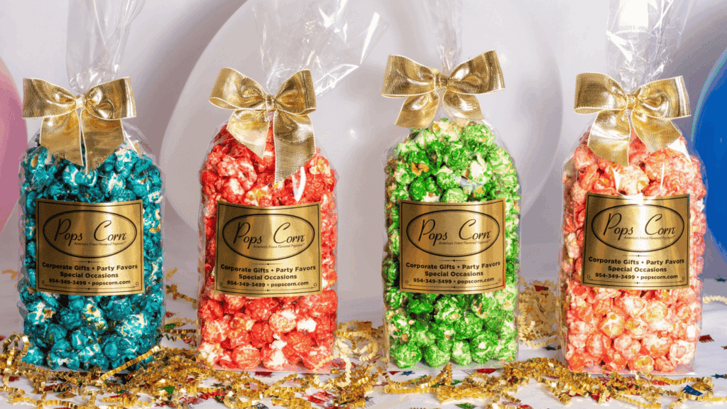colorful flavored popcorn gift bags tied with gold ribbon displayed with confetti and balloons for homemade gifts made easy
