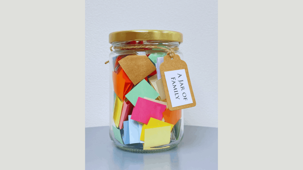 glass jar filled with colorful paper notes and a tag reading a jar of family