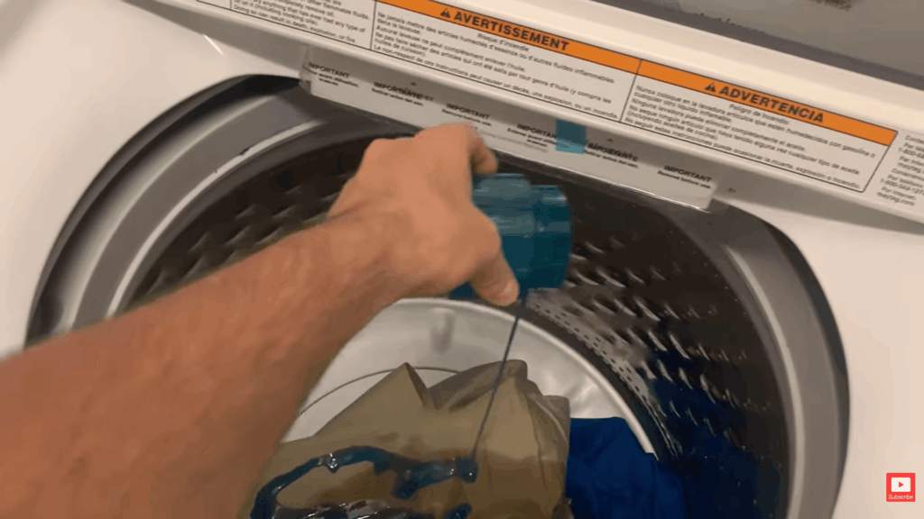 hand pouring cleaning solution into washing machine with fabric inside demonstrating how to remove mold from fabric using laundry treatment method