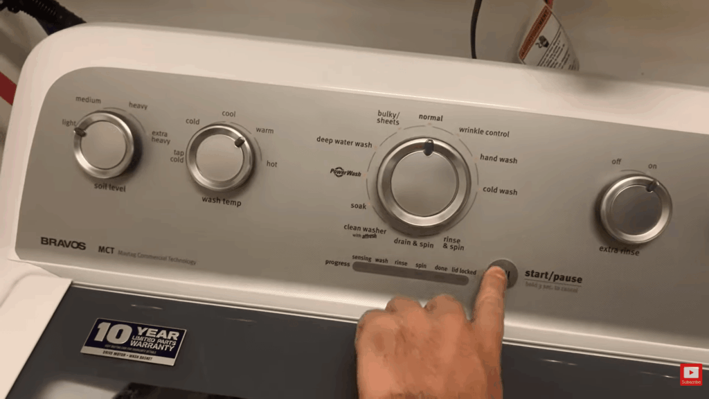 hand pressing start button on washing machine control panel showing final step in how to remove mold from fabric using proper wash settings