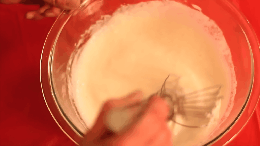 hand whisking white paste in bowl close up for diy glue mixture