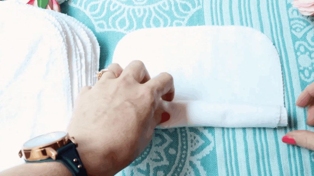hands folding and stacking cloth wipes for homemade dryer sheets preparation