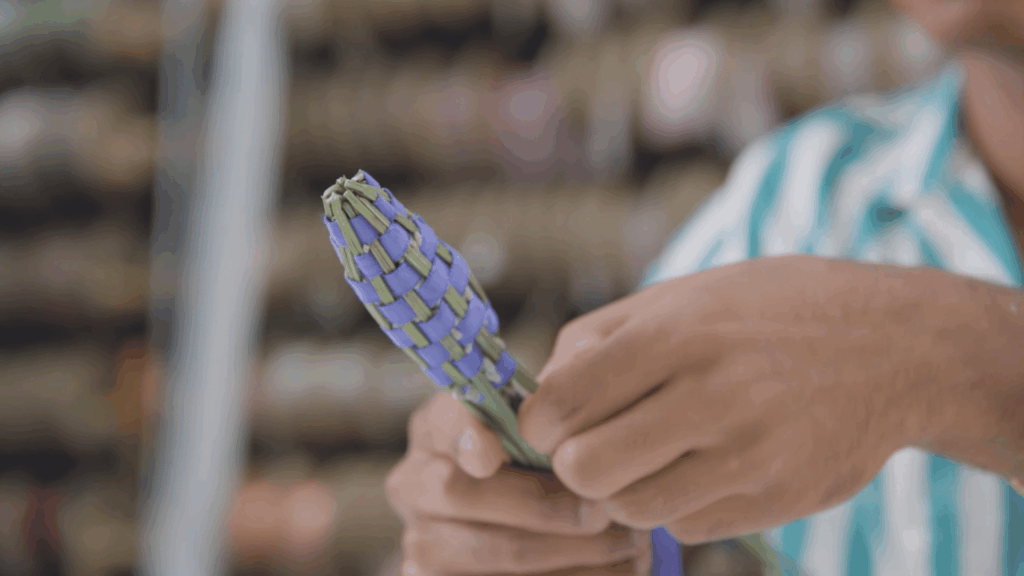 hands holding finished woven lavender bundle with ribbon tie