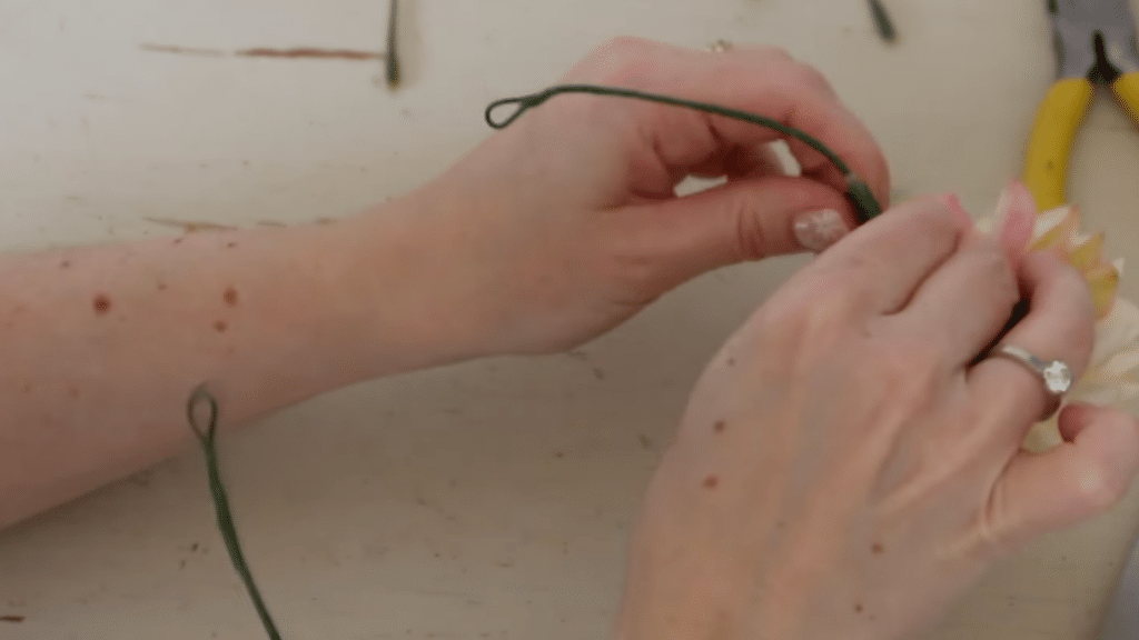 how to make a flower crown by attaching flowers to the wire base with floral tape