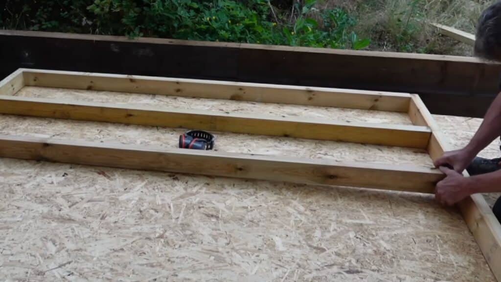 installing vertical studs evenly spaced to strengthen the shed wall and support cladding