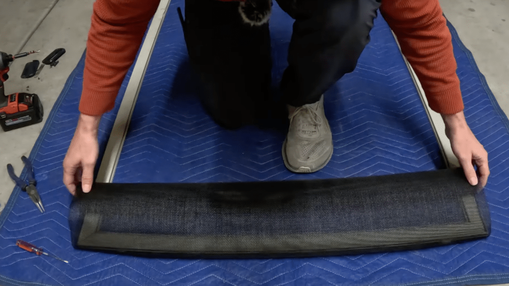 lay the new screen mesh across frame and align evenly while securing the top edge into groove for a tight fit