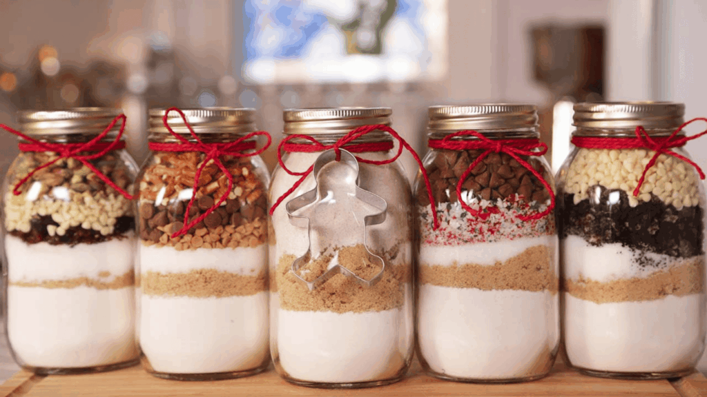 layered baking mix ingredients in glass jars tied with red ribbon and cookie cutter for homemade gifts made easy