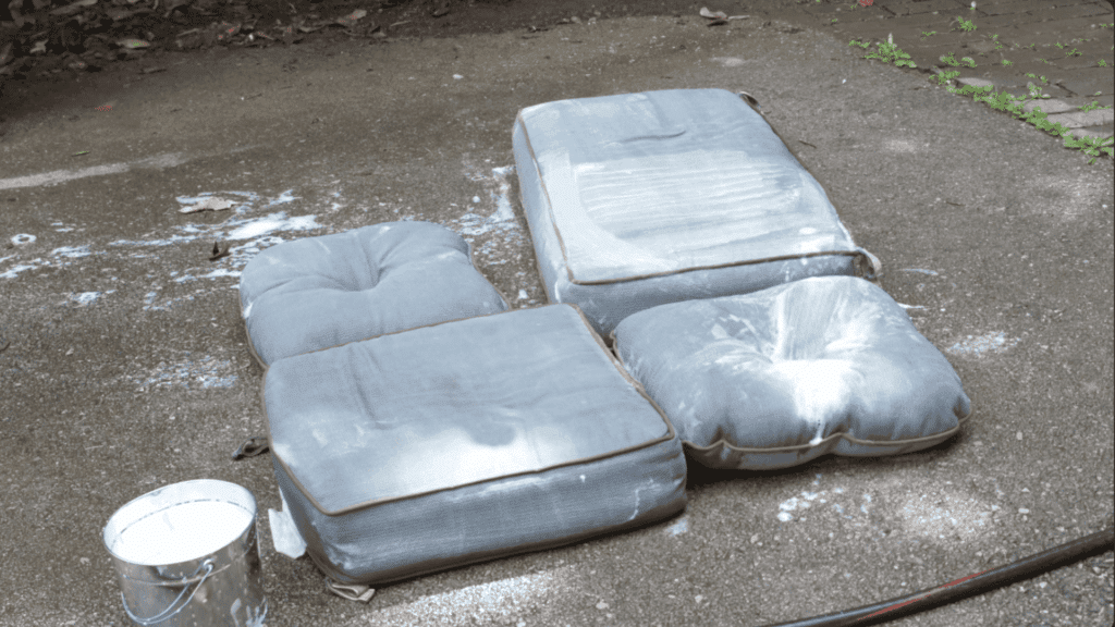 letting cleaning solution sit on outdoor cushions to break down dirt stains and mildew