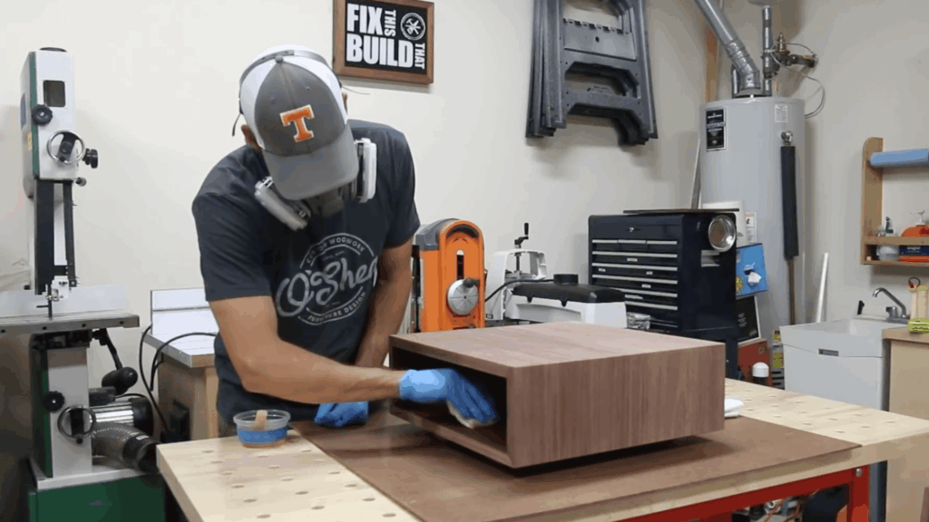 person building drawer and attaching front panel on wooden box in workshop for diy end table