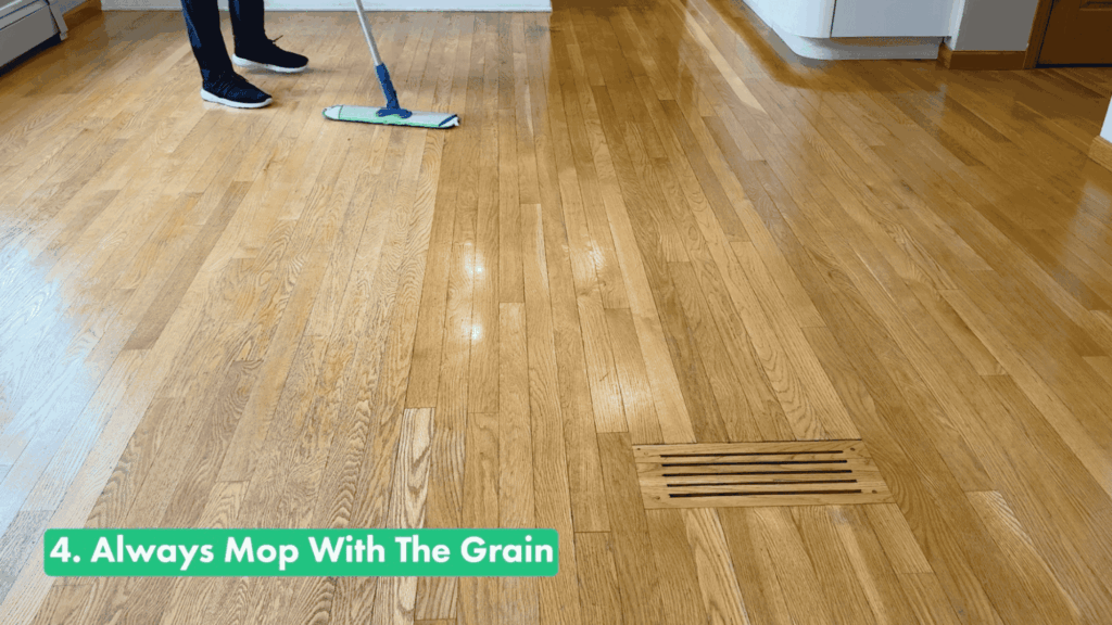 person mopping hardwood floors with the grain using a microfiber flat mop to clean wood floors without streaks