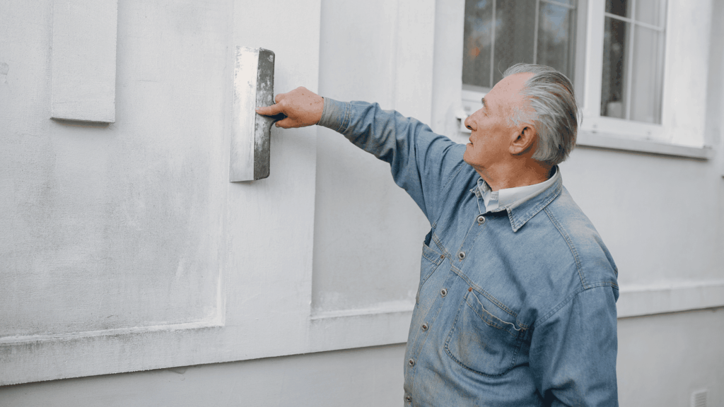 person preparing exterior wall surface showing proper conditions for temperature to paint outside