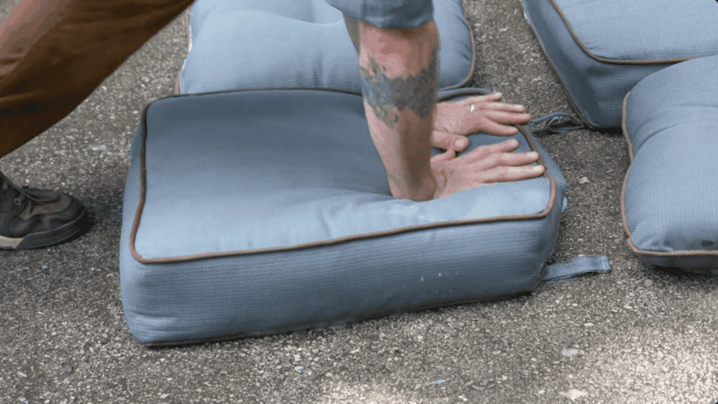 pressing outdoor cushions to remove excess water and help speed up the drying process