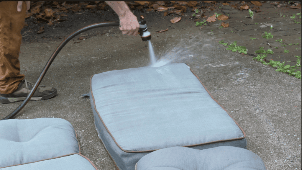 rinsing outdoor cushions thoroughly with a hose to remove soap dirt and cleaning residue