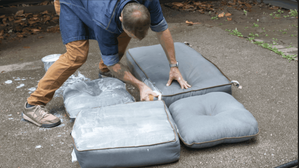 scrubbing outdoor cushions with a brush to remove dirt stains and buildup from the fabric