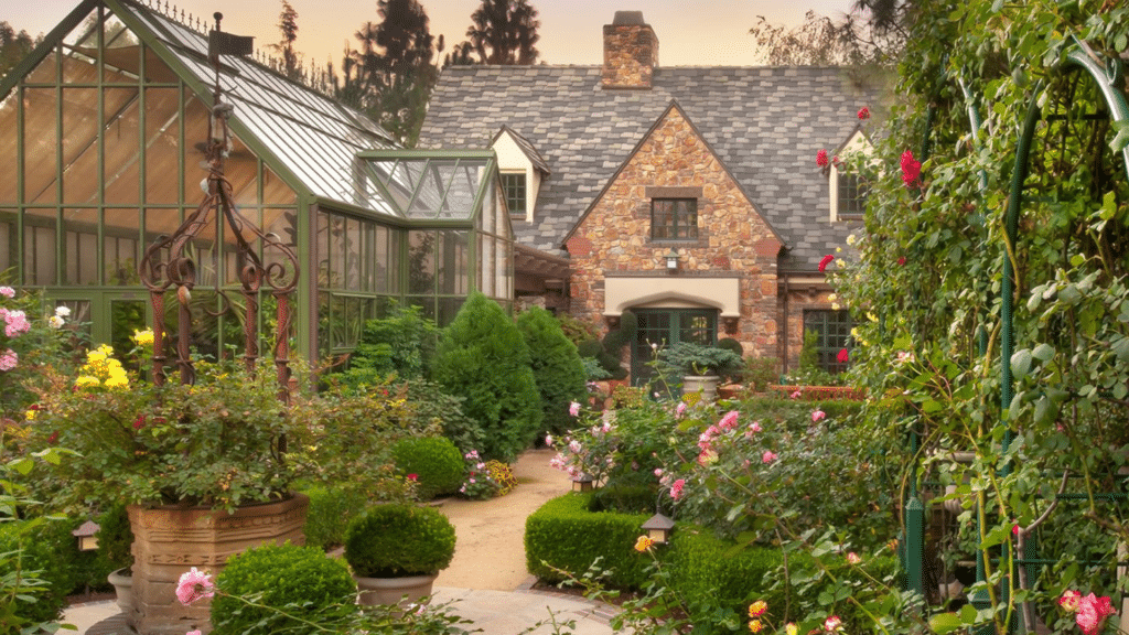 stone tudor cottage with garden and glass greenhouse