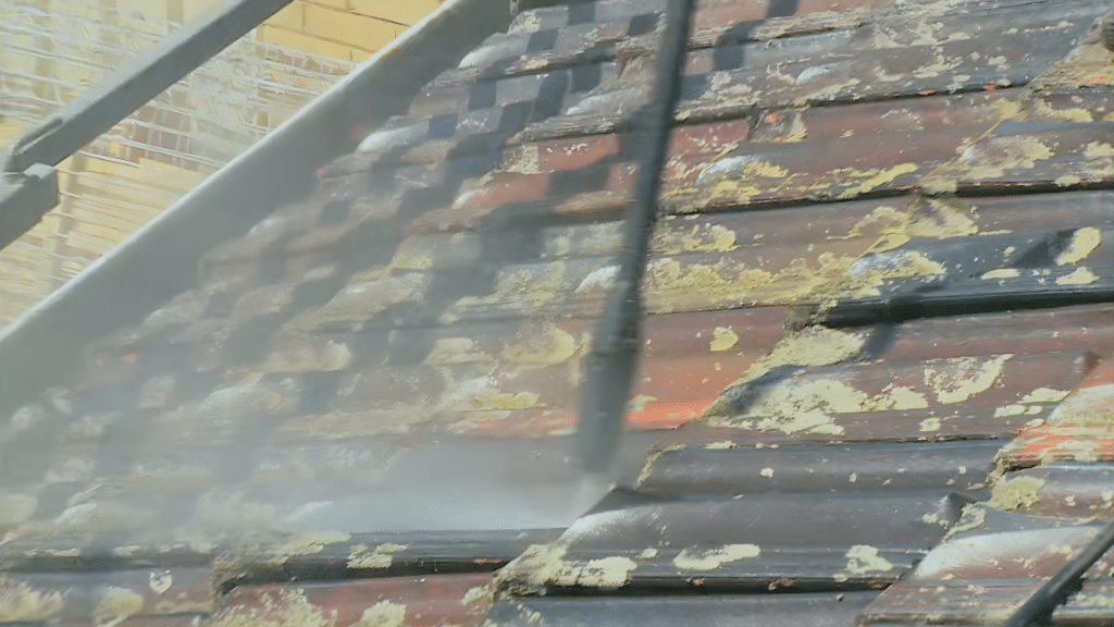 tile roof cleaning using pressure washer to remove moss and dirt buildup from roof tiles for a clean restored surface