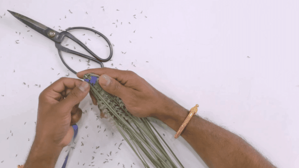 top view hands wrapping lavender bundle with ribbon near scissors