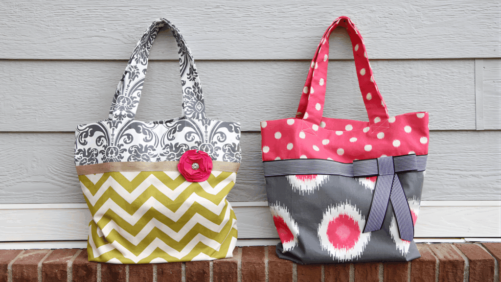 two handmade fabric tote bags with colorful patterns and bows displayed on brick ledge for homemade gifts made easy