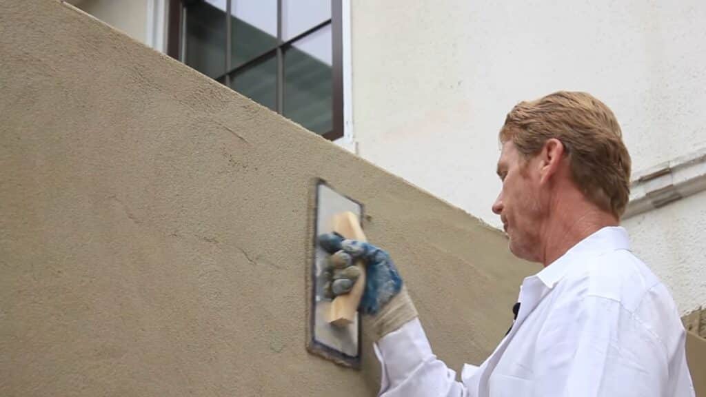 using hard rubber float to compact stucco surface into wire lath