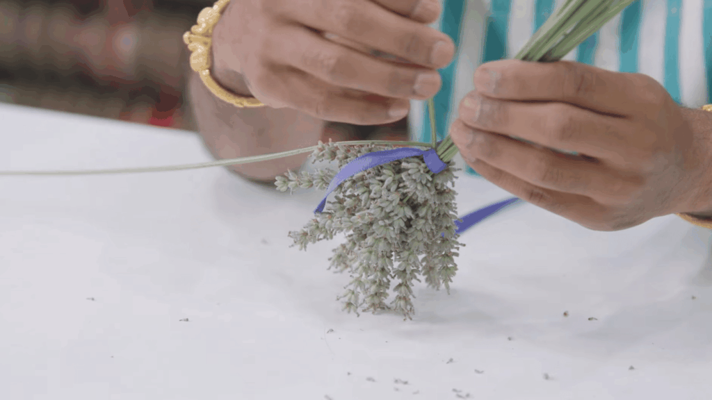 weaving ribbon around lavender stems to shape small bundle