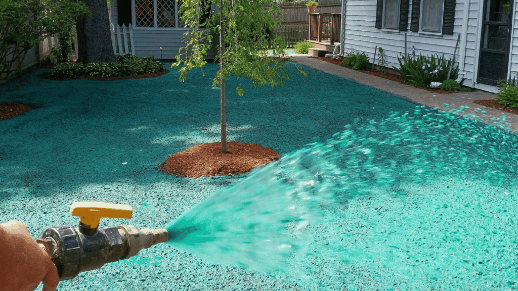 what is hydroseeding everything you need to know hose spraying green hydroseed slurry across prepared residential yard soil around tree and house