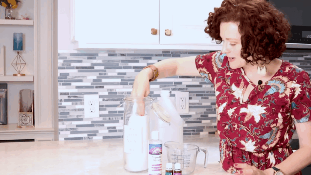 woman placing cloth wipes into jar to soak in solution for homemade dryer sheets