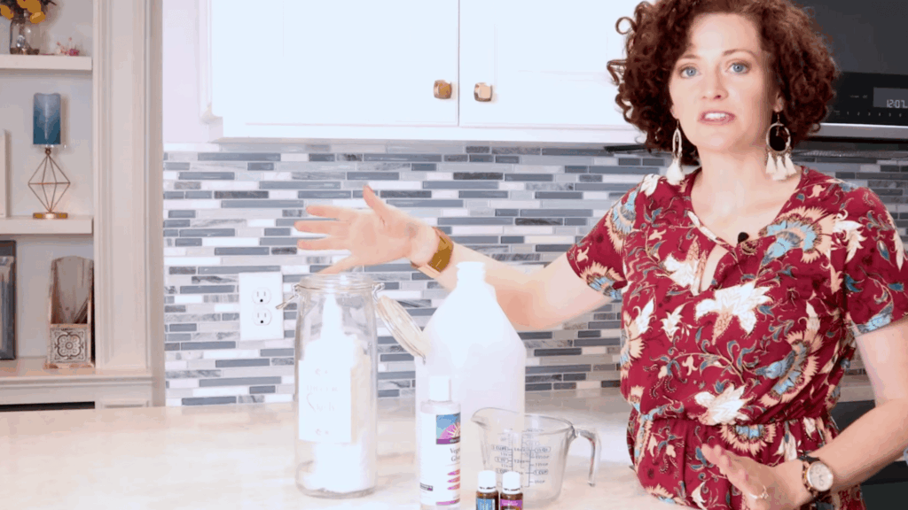 woman showing jar of homemade dryer sheets ready to use in dryer with laundry