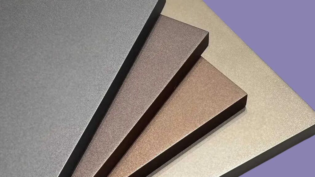 Close-up of four powder-coated aluminum panels in different shades of gray, brown, and gold, stacked on top of each other against a purple background.