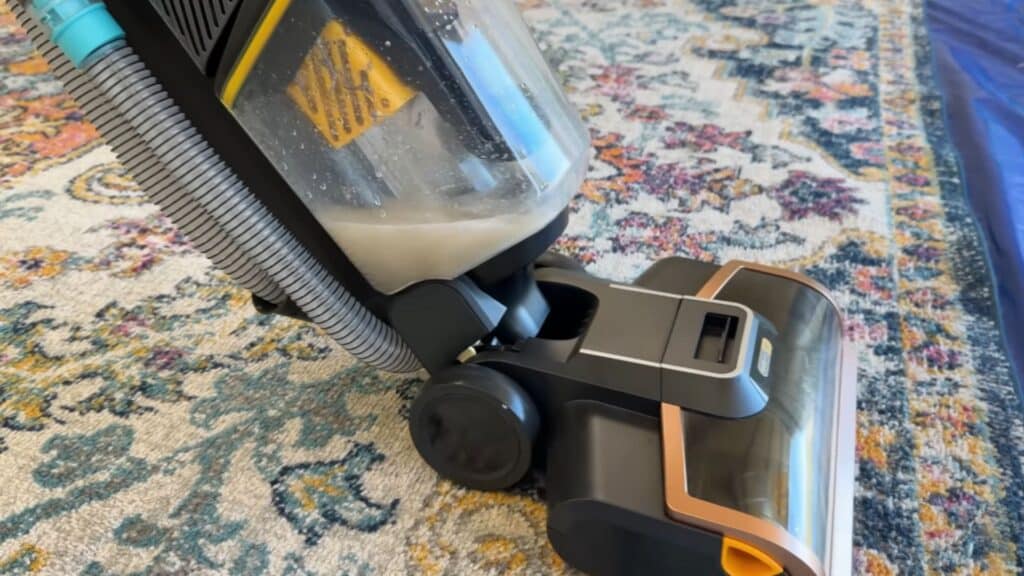 a close view of a carpet cleaning machine extracting dirty water from a rug during deep cleaning process