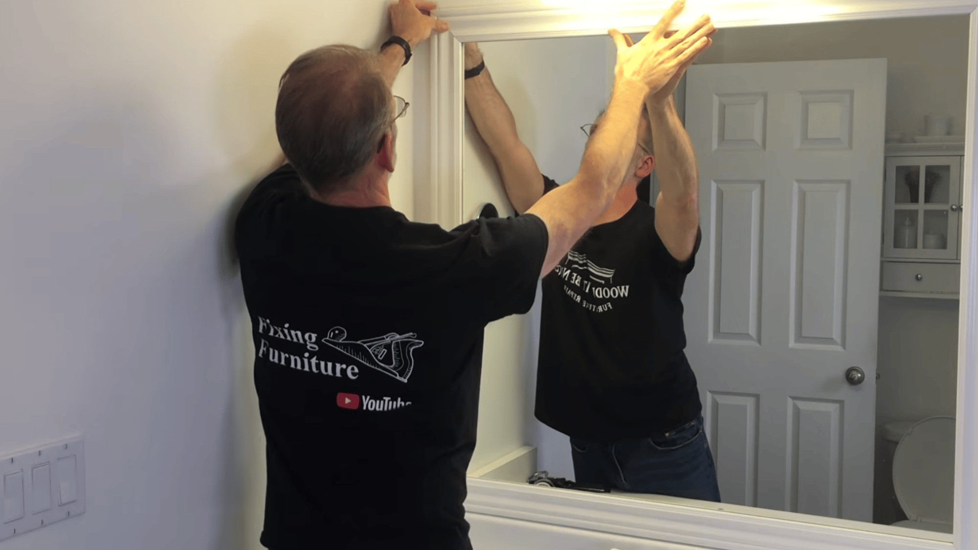 adjusting trim corners on mirror frame to align edges properly and ensure tight fit for clean finish