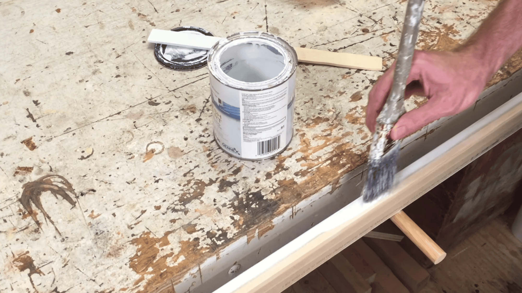 applying primer and paint on wood trim with brush to prepare surface for mirror frame finishing process