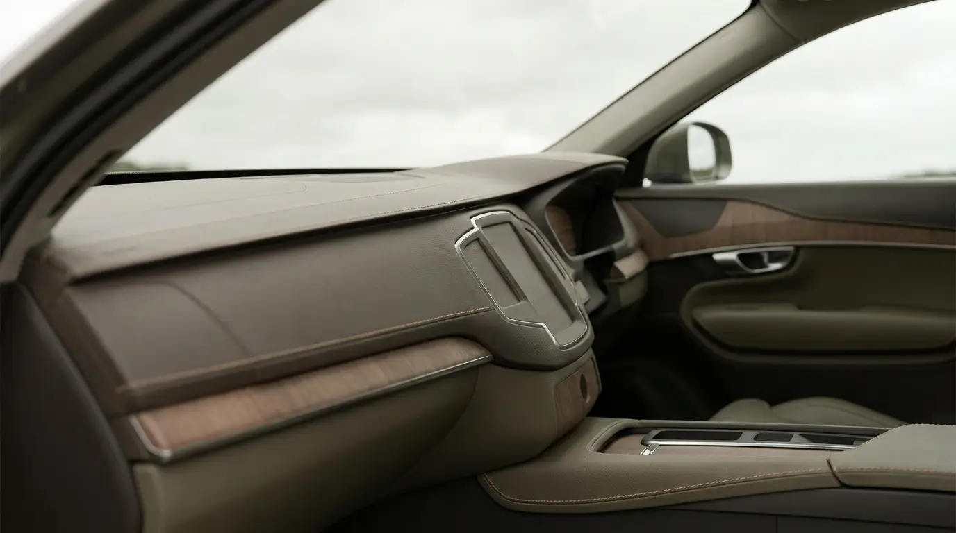 Car interior featuring beige leather dashboard and wooden trim with panoramic view window
