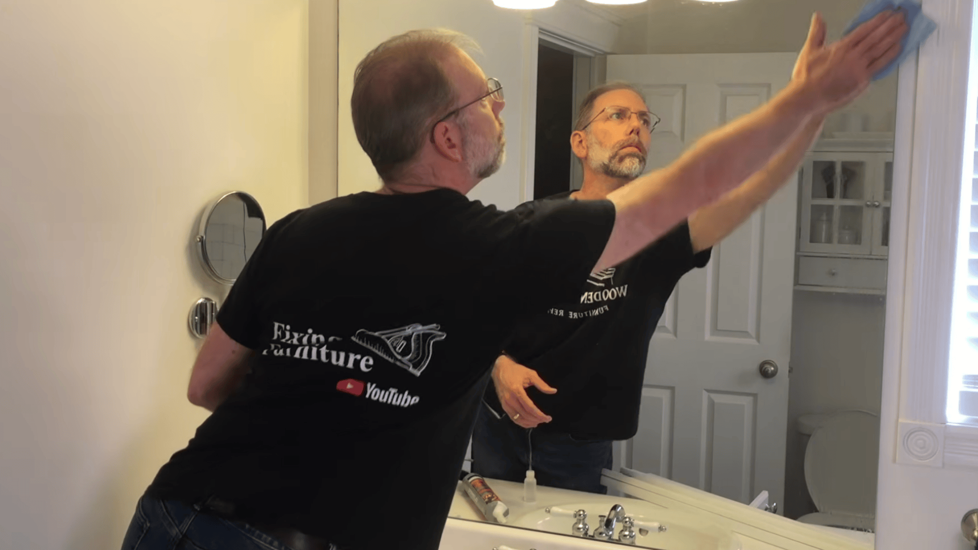 cleaning mirror surface with cloth to remove dust and grease before attaching trim for mirror frame process