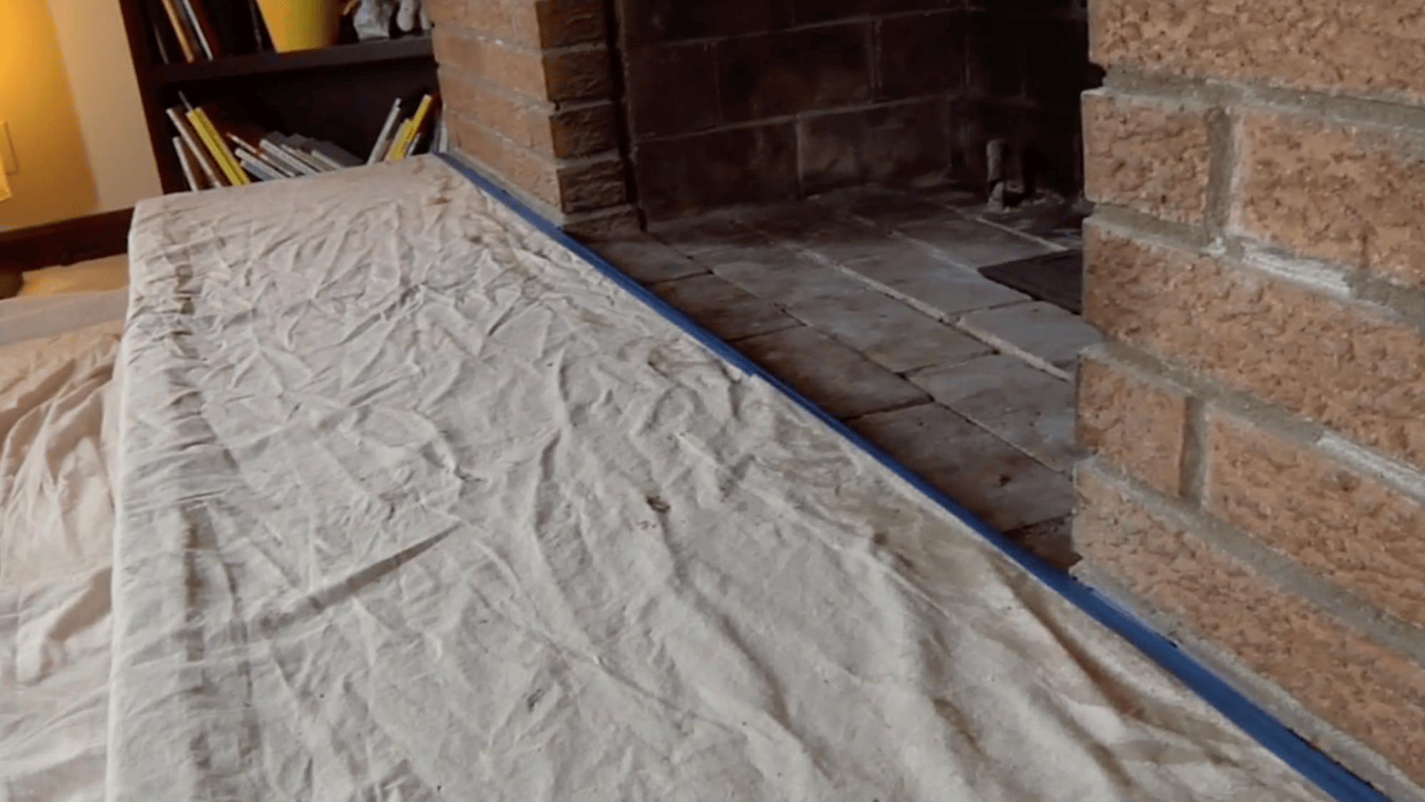 cloth covering floor around brick fireplace to prep and protect the area