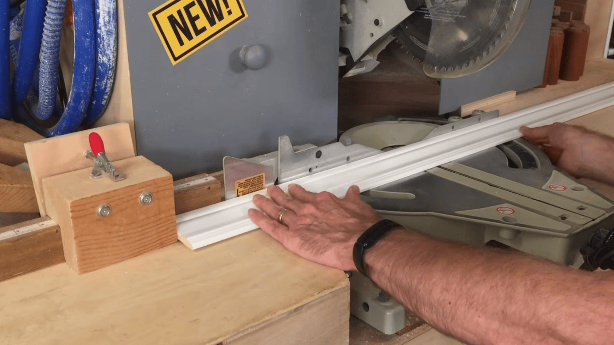 cutting trim on miter saw at forty five degree angle to create clean corners for mirror frame pieces