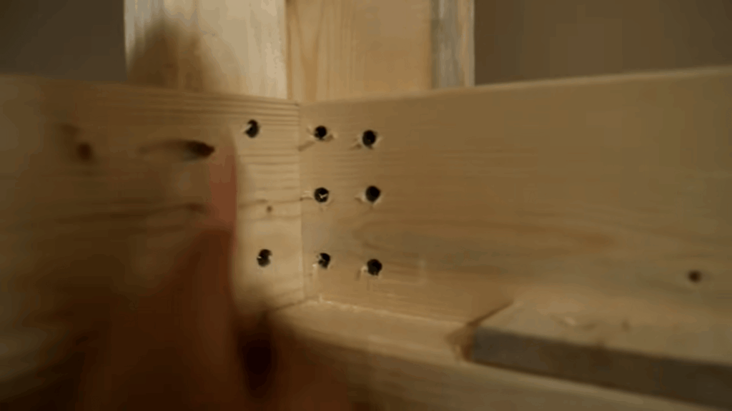 diy bunk beds assembly showing close view of wooden frame corner with drilled holes during building process