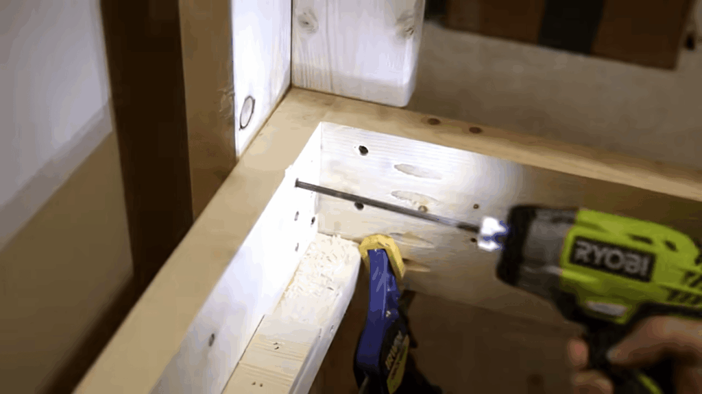 diy bunk beds assembly with power drill fastening wooden frame corner during indoor construction process