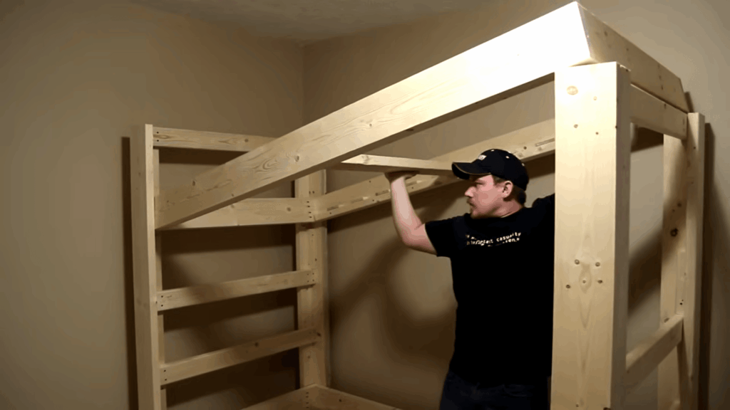 diy bunk beds project with person assembling wooden frame and ladder structure inside a room