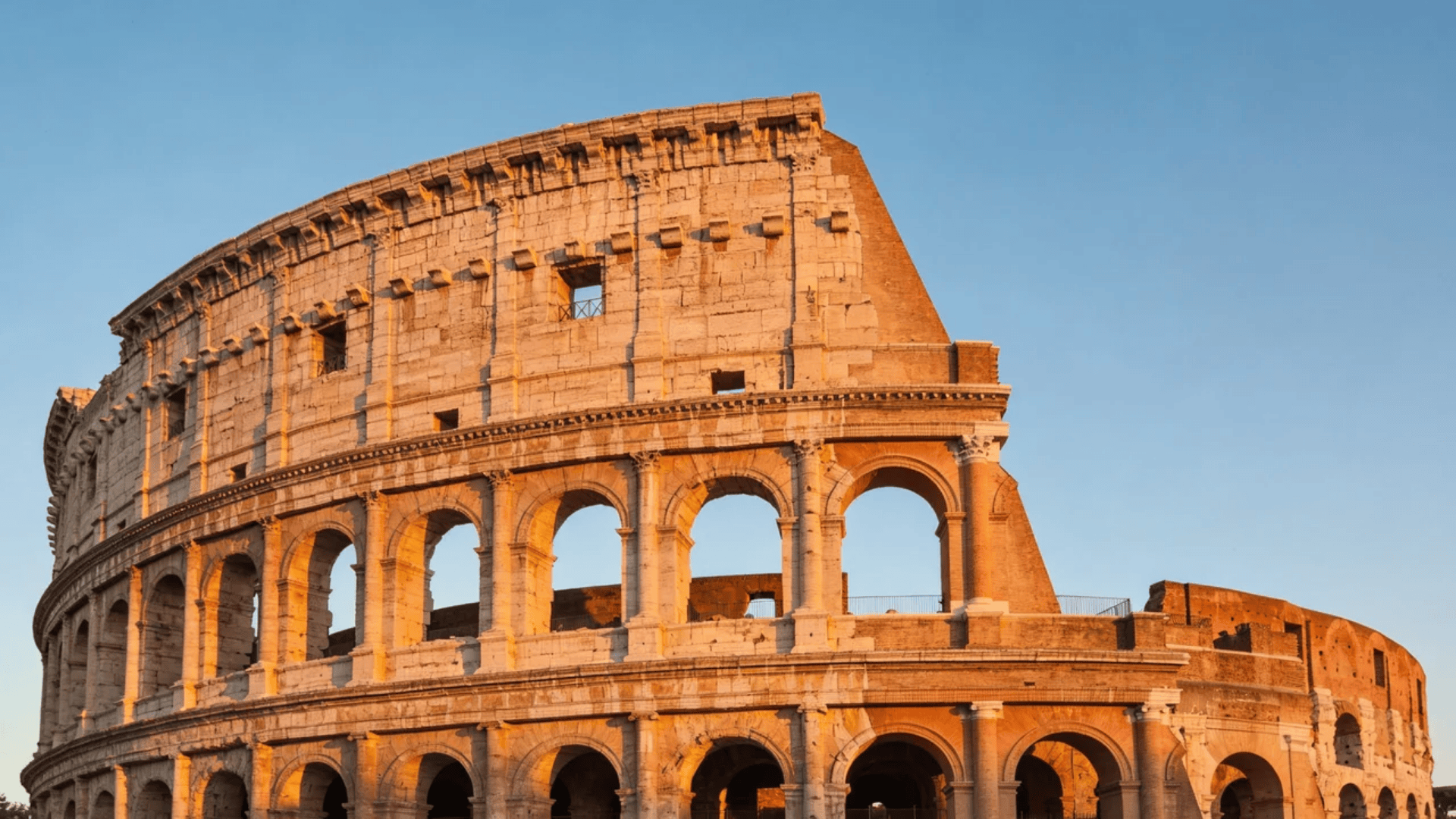 european architecture ancient roman colosseum with arches glowing in warm sunset light
