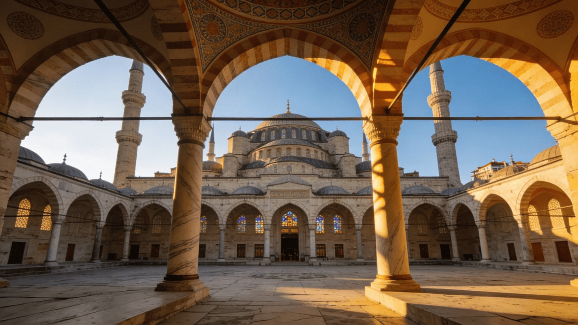 european architecture grand mosque courtyard with arches domes and minarets in warm sunlight